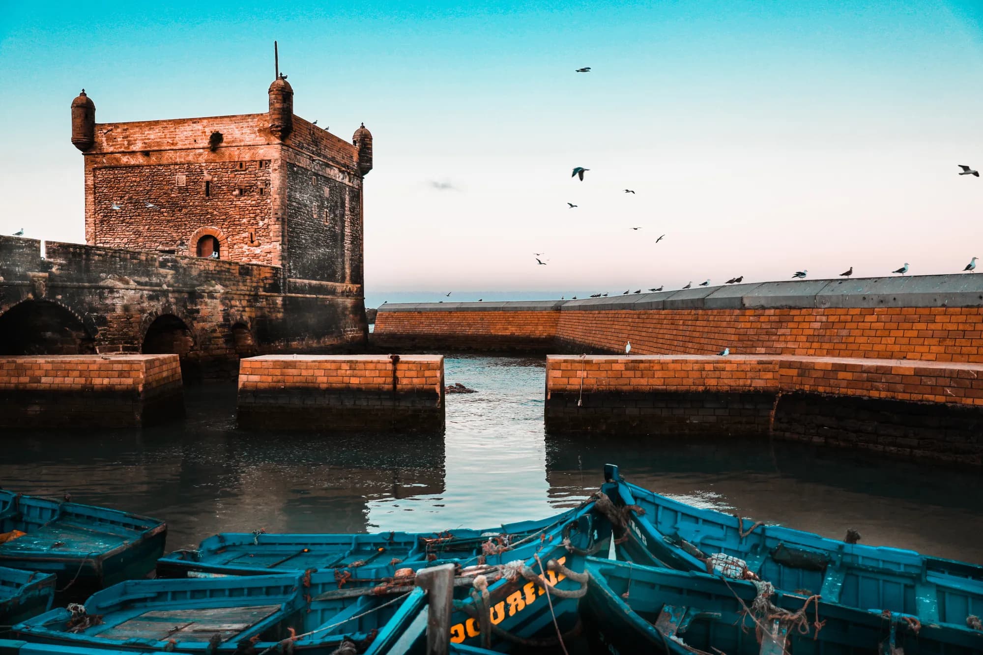 The Skala fortress and blue fishing boats in the harbour of Essaouira, Morocco