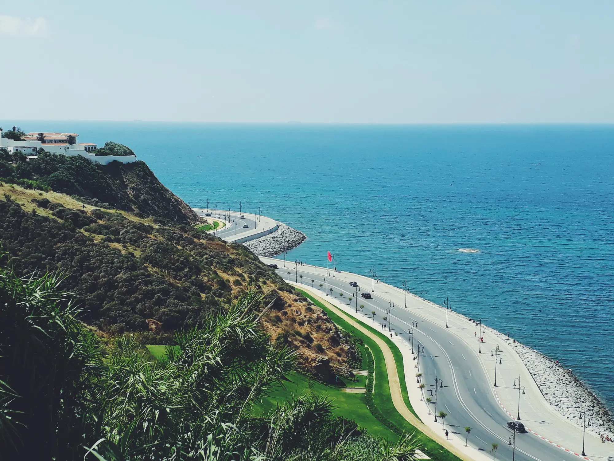 An aerial view of Tangier's coastal corniche road curving along the Mediterranean, Morocco